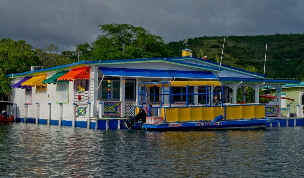 A colorful floating house and boat on the water at La Parguera, Lajas, Puerto Rico