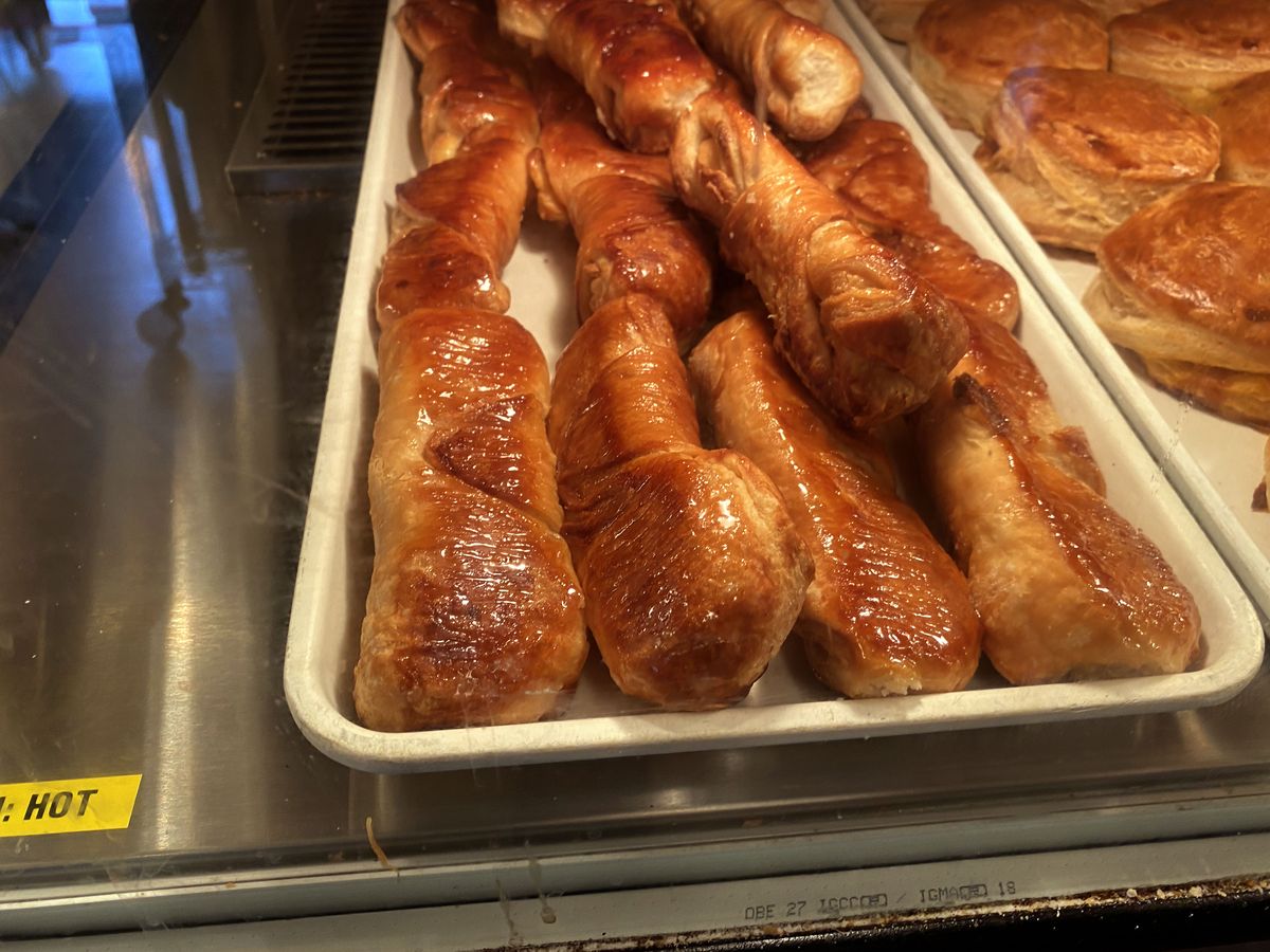 A bakery display case full of glazed quesito pastries at a panaderia in San Juan, Puerto Rico